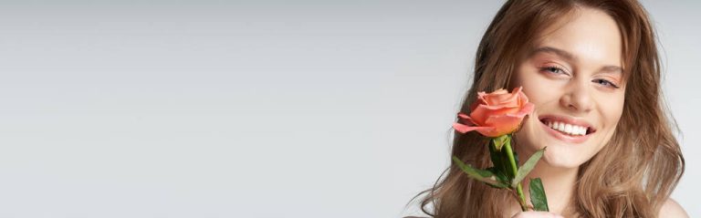 stock photo beauty shot laughing woman blue eyes peachy rose face grey 768x239